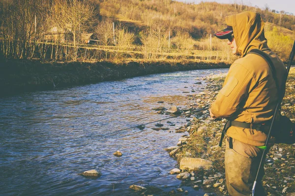 Balıkçı bir alabalık bir dağ nehir üzerinde yakalar. — Stok fotoğraf