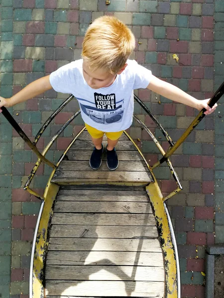 The boy is riding on a swing-boat — Stock Photo, Image