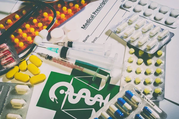 Compresse, pillole e uno stetoscopio su un tavolo — Foto Stock