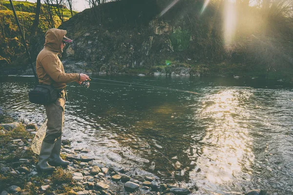 Pescatore cattura una trota su un fiume di montagna — Foto Stock