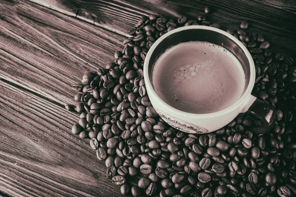 Taza de café y granos de café sobre un fondo de madera —  Fotos de Stock