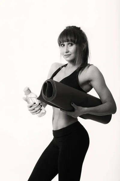 Chica deportiva con una esterilla de yoga — Foto de Stock