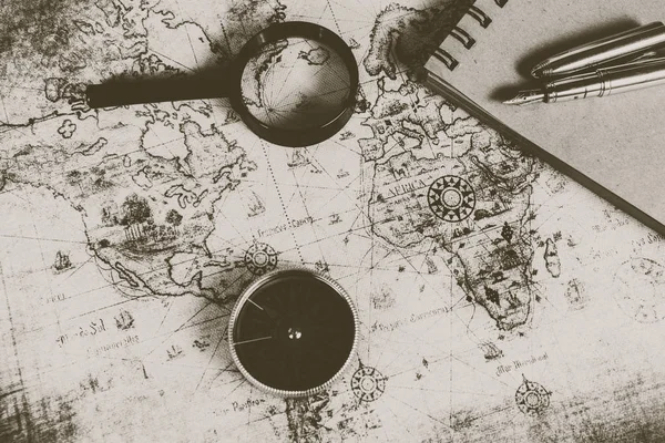 En gammal karta, kompass och ett förstoringsglas — Stockfoto