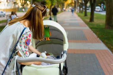 Anne üzerinde bir bebek arabası