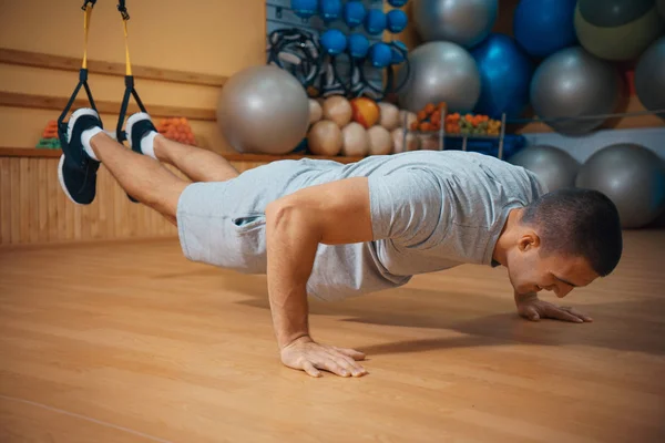 Ung man är engagerad i ett gym i trx — Stockfoto