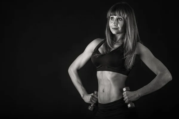 Girl bodybuilder with dumbbells black and white — Stock Photo, Image