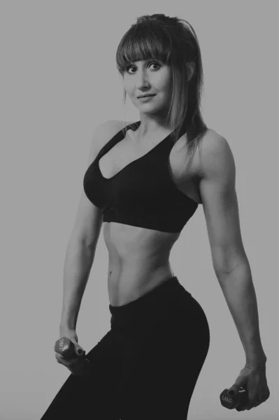 Girl posing with dumbbells in the studio — ストック写真