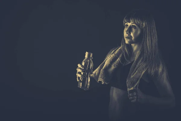 Chica después de entrenar con agua y una toalla —  Fotos de Stock