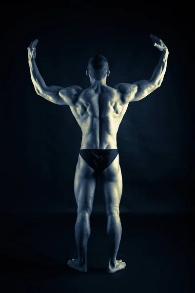 Bodybuilder poses in full growth — Stock Photo, Image