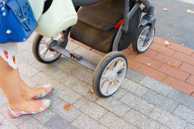 Anne üzerinde bir bebek arabası