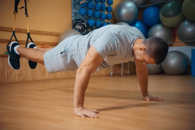 Genç adam bir spor salonunda trx devreye girer