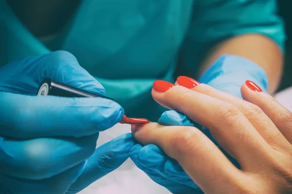 Maestro de manicura pinta clavos en rojo —  Fotos de Stock