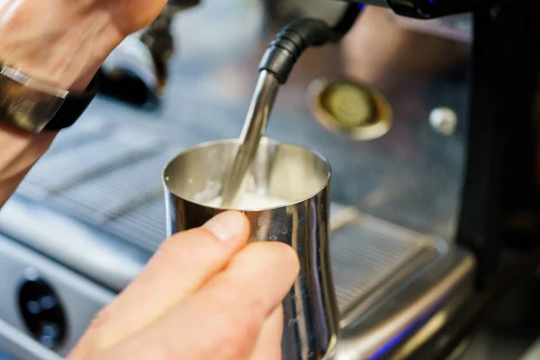 Eine Kaffeemaschine schenkt Milch ein — Stockfoto