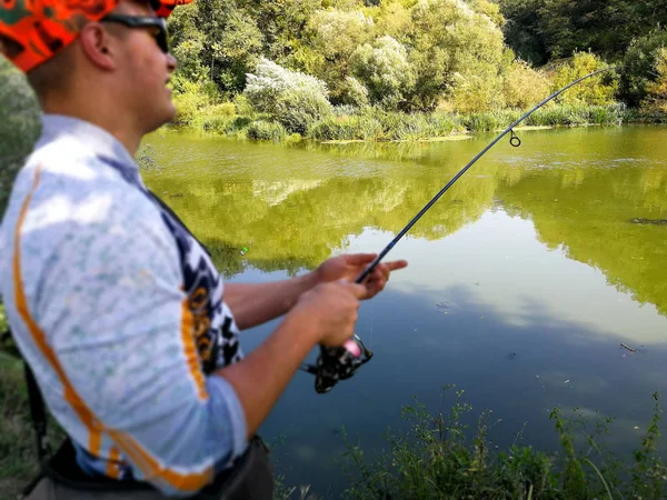 O pescador está pescando no lago no verão — Fotografia de Stock