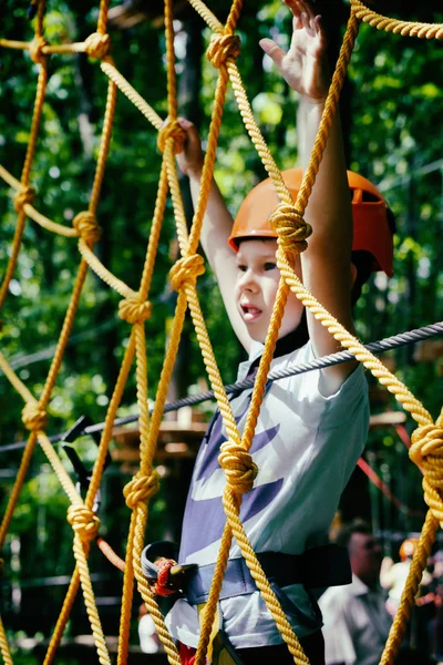 De jongen klimt het touwbaanparcours — Stockfoto