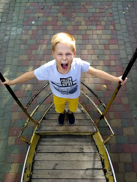 The boy is riding on a swing-boat — Stock Photo, Image