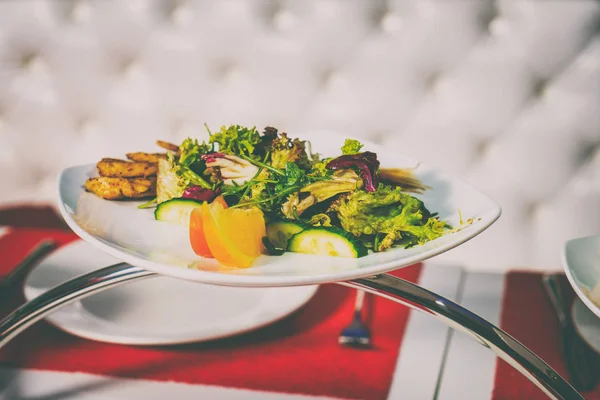 Placa con ensalada en la mesa — Foto de Stock