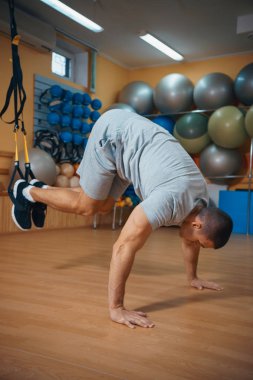 Genç adam bir spor salonunda trx devreye girer