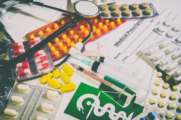 Таблетки, таблетки и стетоскоп на столе — стоковое фото