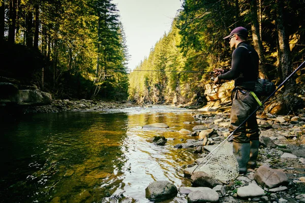 Fisherman on a beautiful mountain river in the forest — Stock Photo, Image