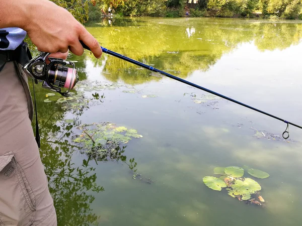 Mano di un pescatore con una canna da pesca — Foto Stock