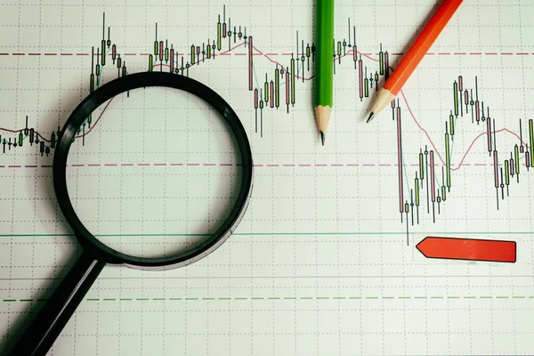 Financiële graphics loep en potloden — Stockfoto