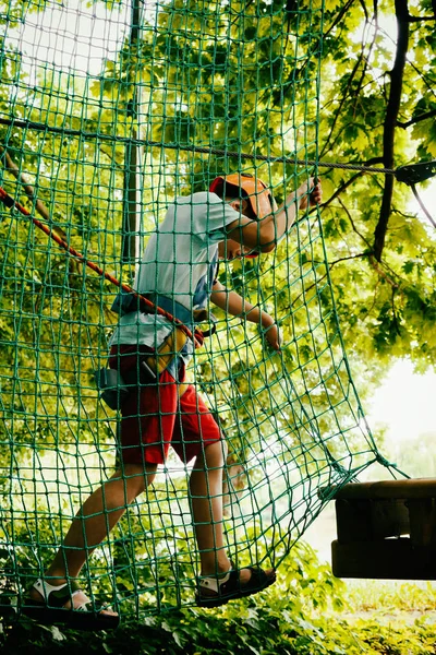 Хлопчик піднімається на підвісний парк — стокове фото