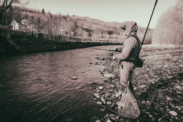 Pescador atrapa una trucha en un río de montaña —  Fotos de Stock