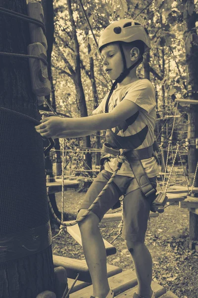 男孩爬上了一个绳索公园。 — 图库照片