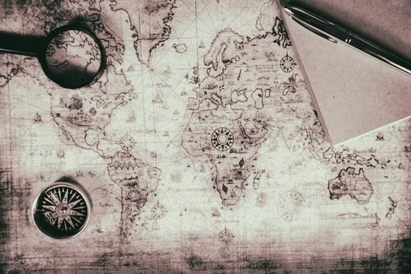 Un mapa antiguo, una brújula y una lupa —  Fotos de Stock