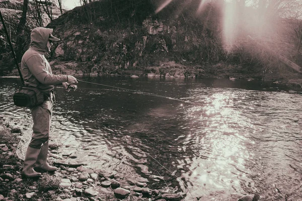 Pescarul prinde un păstrăv pe un râu de munte — Fotografie, imagine de stoc