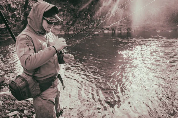 Fiskare fångar en öring på en mountain river — Stockfoto