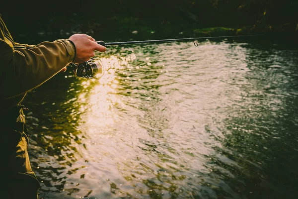 Pescatore cattura una trota su un fiume di montagna — Foto Stock