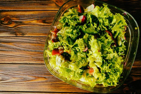 stock image Green vegetable salad on a wooden background