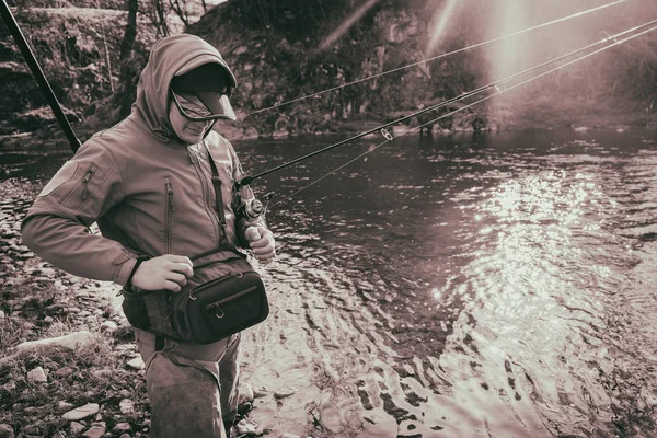 Visser vangt een forel op een berg rivier — Stockfoto