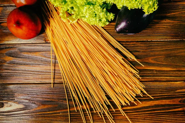 Spagetti ve sebze ahşap arka plan üzerinde