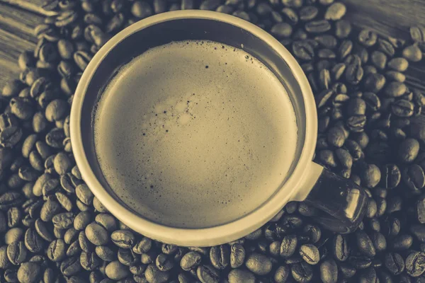 Taza de café y granos de café sobre un fondo de madera — Foto de Stock