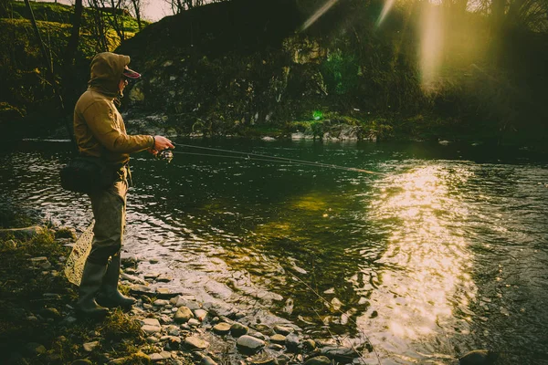 Pêcheur attrape une truite sur une rivière de montagne — Photo