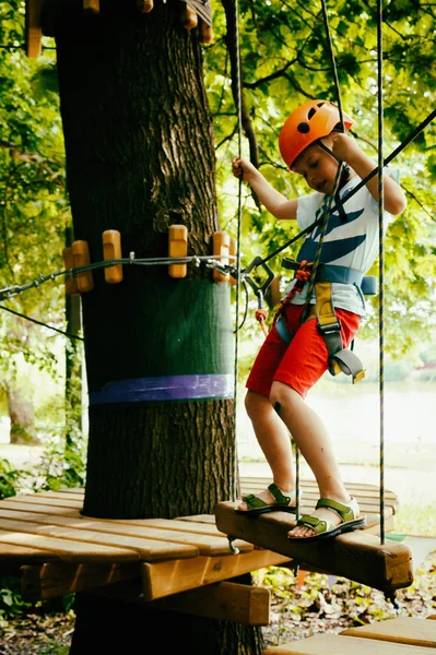 El chico sube a un parque colgante — Foto de Stock