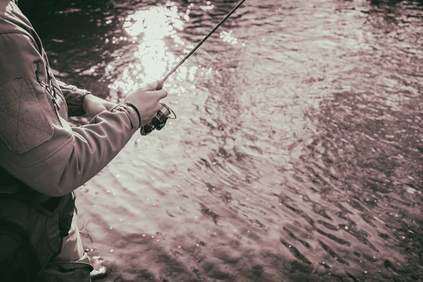 Fischer fängt eine Forelle in einem Gebirgsfluss — Stockfoto
