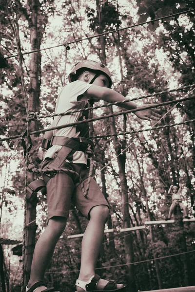 The boy climbs a pendant park — Stock Photo, Image