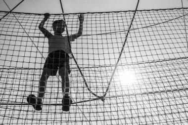 Çocuk ip parkında oynuyor.