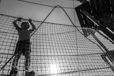 Çocuk ip parkında oynuyor.