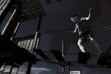 Çocuk ip parkında oynuyor.