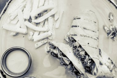 Arkaplanda tabak yemeği olan burrito.