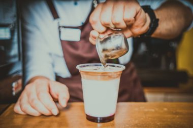 Barista kafenin arka planında kahve yapıyor.