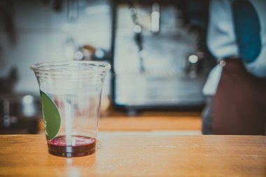 Barista kafenin arka planında kahve yapıyor.