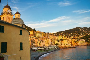 İtalya 'da Camogli' de kilise kulesi ve renkli sahil kasabası gün batımının altında parlıyordu..