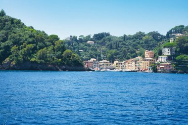 İtalya 'nın Ligurian kıyısındaki mavi Akdeniz üzerinde yeşil tepeleri ve villaları olan Rocky sahili..