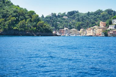 İtalya 'nın Ligurian kıyısındaki mavi Akdeniz üzerinde yeşil tepeleri ve villaları olan Rocky sahili..